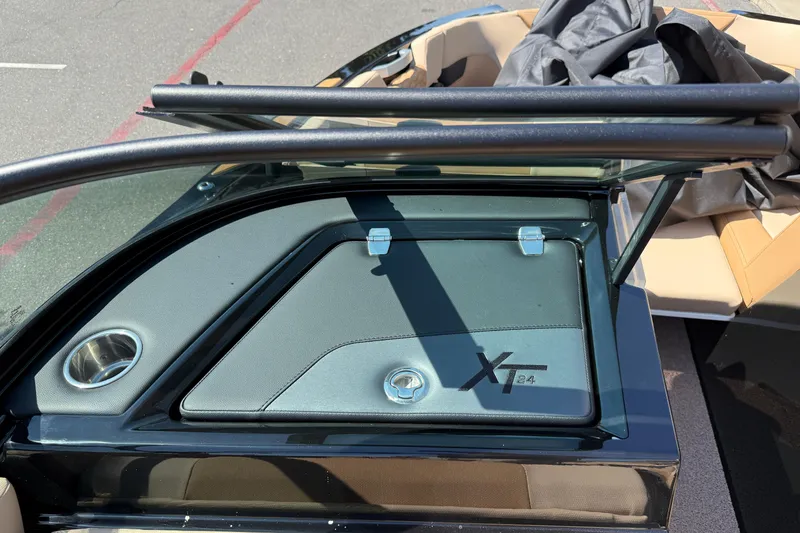 Slide: The Image of 2025 MasterCraft XT24 boat interior with storage compartment and cup holder. - 32