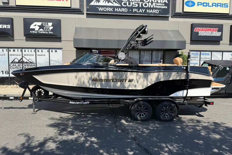 Slide: The Image of 2025 MasterCraft XT24 boat on trailer outside dealership. - 4