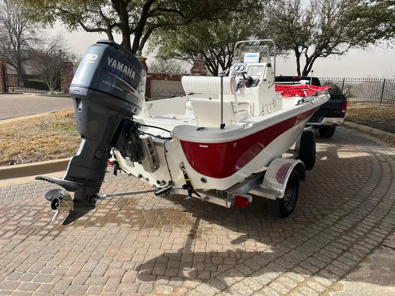 Slide: The Image of 2012 NauticStar 1810 boat with Yamaha engine on a trailer, parked outdoors. - 11