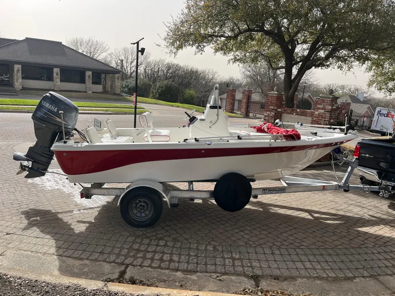 Slide: The Image of 2012 NauticStar 1810 boat on trailer, parked outdoors, with Yamaha outboard motor. - 12