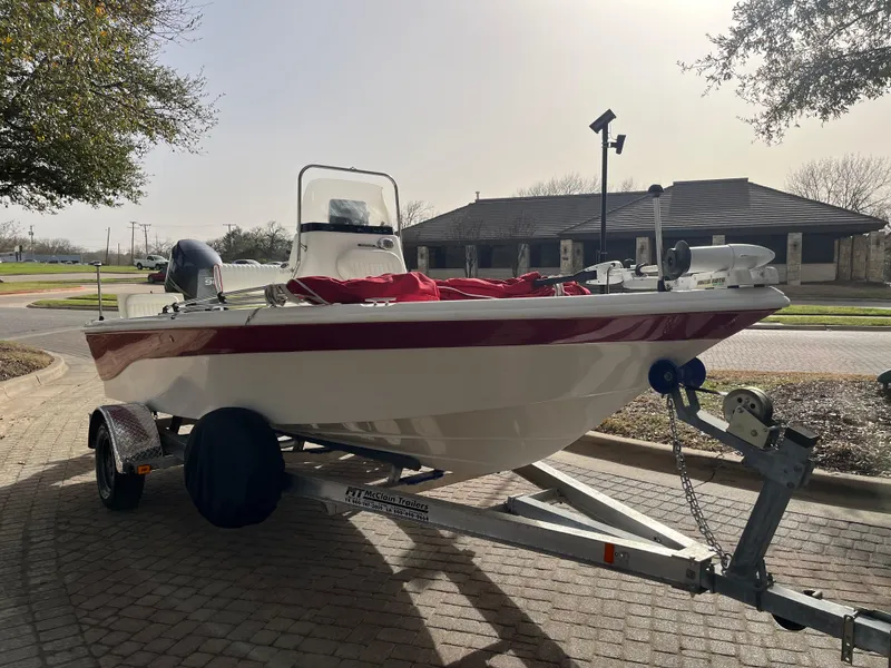 Slide: The Image of 2012 NauticStar 1810 boat on trailer, parked on a paved driveway. - 14