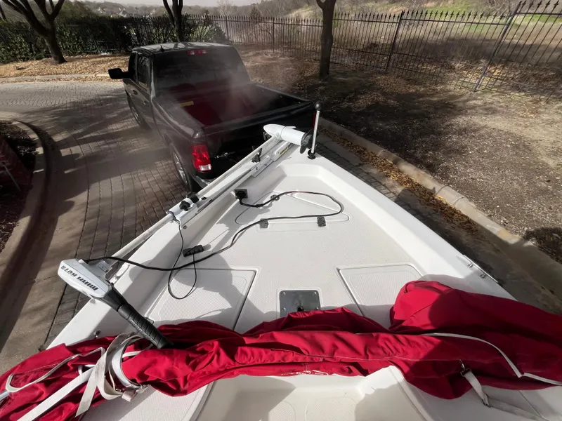 Slide: The Image of 2012 NauticStar 1810 boat on trailer, red cover, parked behind black truck. - 18