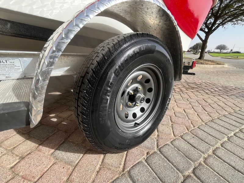Slide: The Image of Trailer wheel of a 2012 NauticStar 1810 boat on a paved surface. - 19