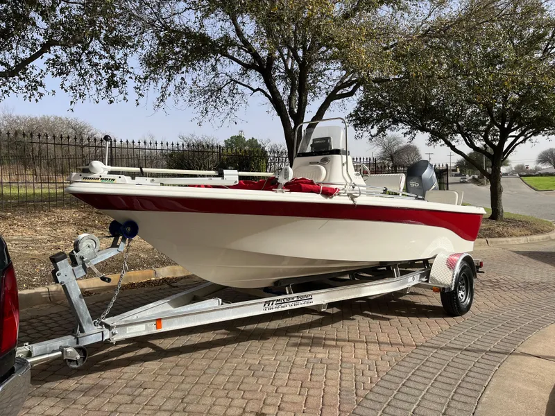 Slide: The Image of 2012 NauticStar 1810 boat on trailer, parked outdoors near trees. - 2