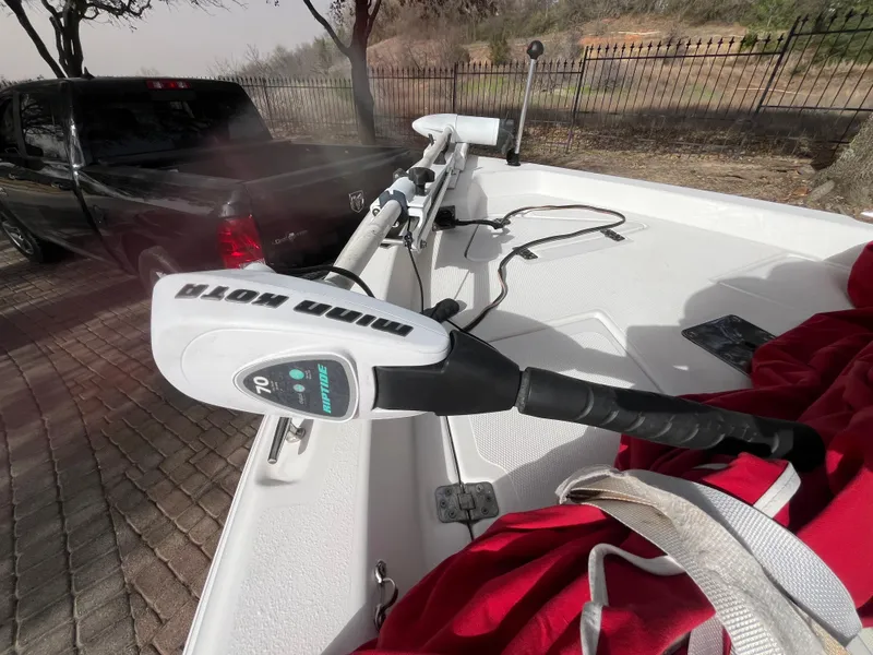 Slide: The Image of 2012 NauticStar 1810 boat with Minn Kota trolling motor, parked near a black truck. - 21