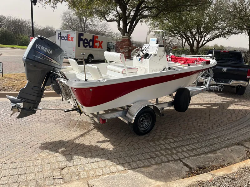Slide: The Image of 2012 NauticStar 1810 boat with Yamaha motor on trailer, parked near FedEx trucks. - 3