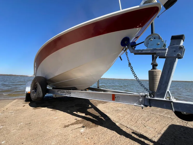 Slide: The Image of 2012 NauticStar 1810 boat on trailer by the water, clear blue sky. - 35