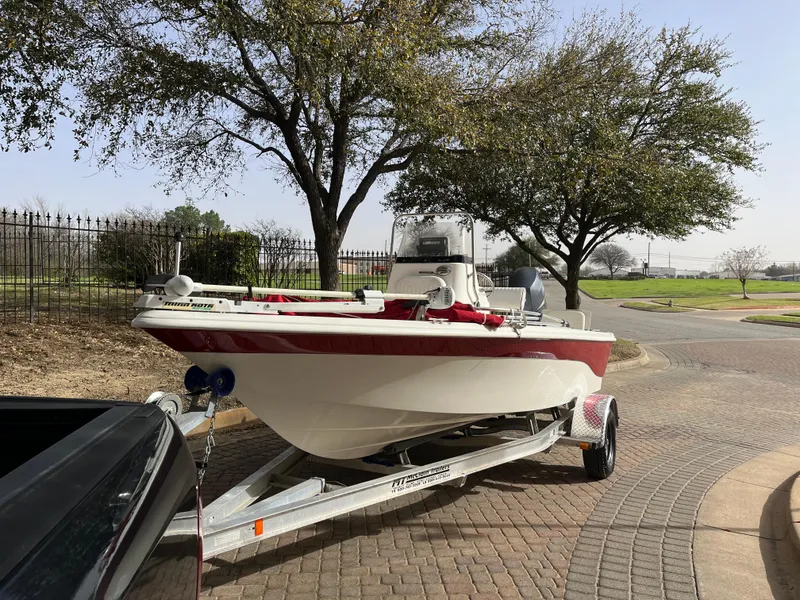 Slide: The Image of 2012 NauticStar 1810 boat on trailer, parked outdoors near trees. - 4