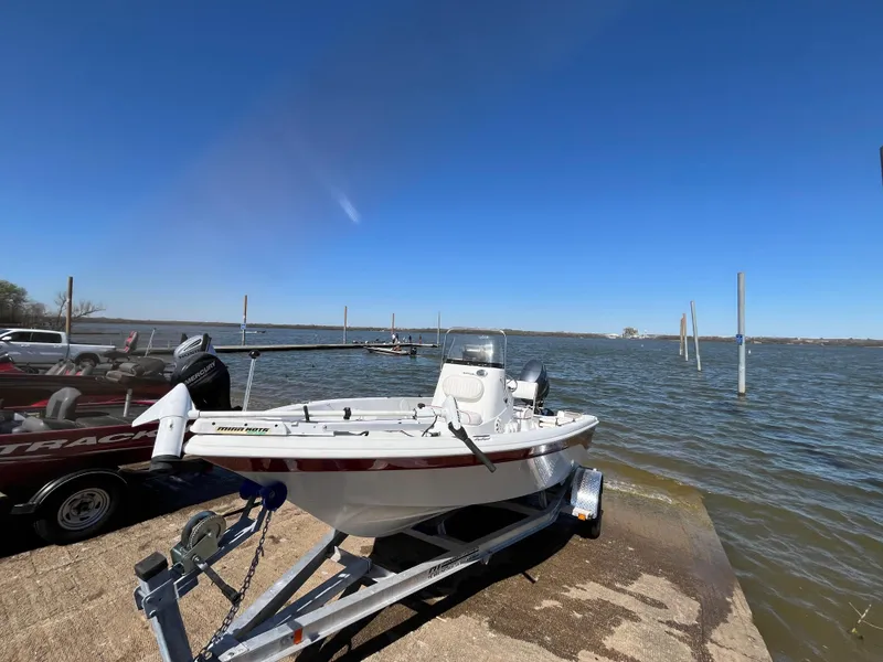 Slide: The Image of 2012 NauticStar 1810 boat on trailer by a lake under clear blue sky. - 41