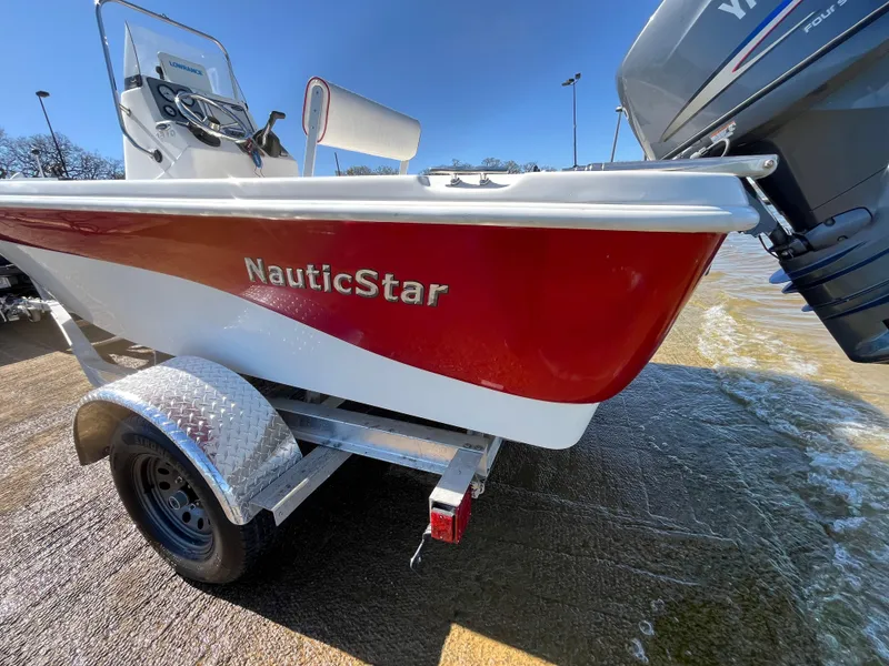 Slide: The Image of Red 2012 NauticStar 1810 boat on trailer, parked near water. - 46