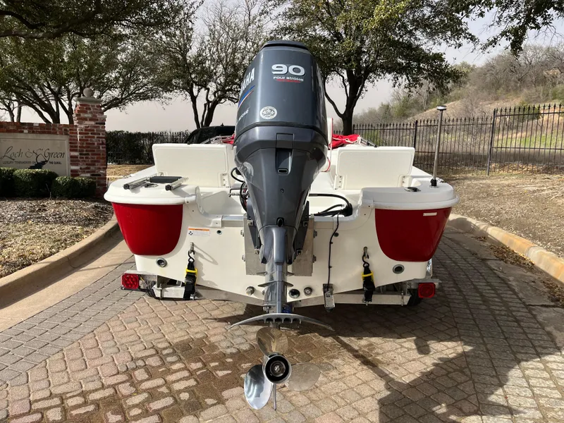 Slide: The Image of 2012 NauticStar 1810 boat with Yamaha 90 outboard motor, parked on a paved driveway. - 8