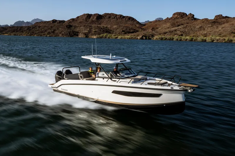 Slide: The Image of Navan S30 2025 boat cruising on a lake with rocky hills in the background. - 0