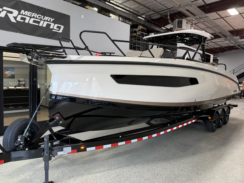 Slide: The Image of Navan S30 2025 boat on trailer in showroom, featuring sleek design and Mercury Racing branding. - 1