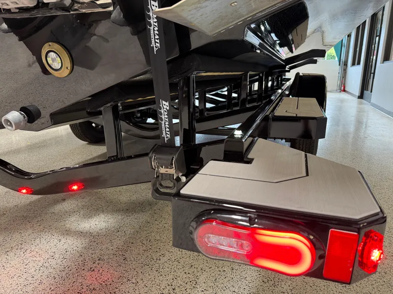 Slide: The Image of Navan S30 2025 trailer with red LED lights and sleek design in a garage setting. - 13