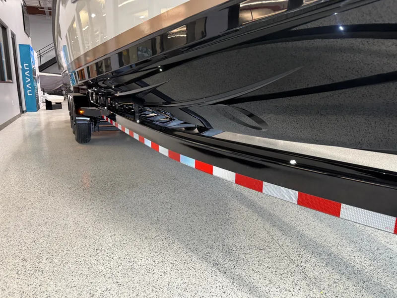 Slide: The Image of 2025 Navan S30 boat on trailer, glossy black hull, indoor showroom. - 14