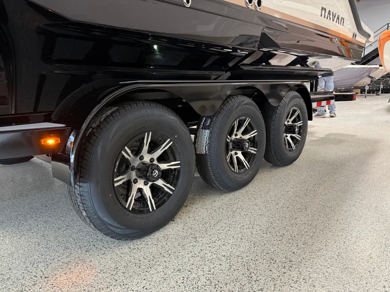Slide: The Image of Trailer with three wheels for 2025 Navan S30 boat, parked indoors. - 7