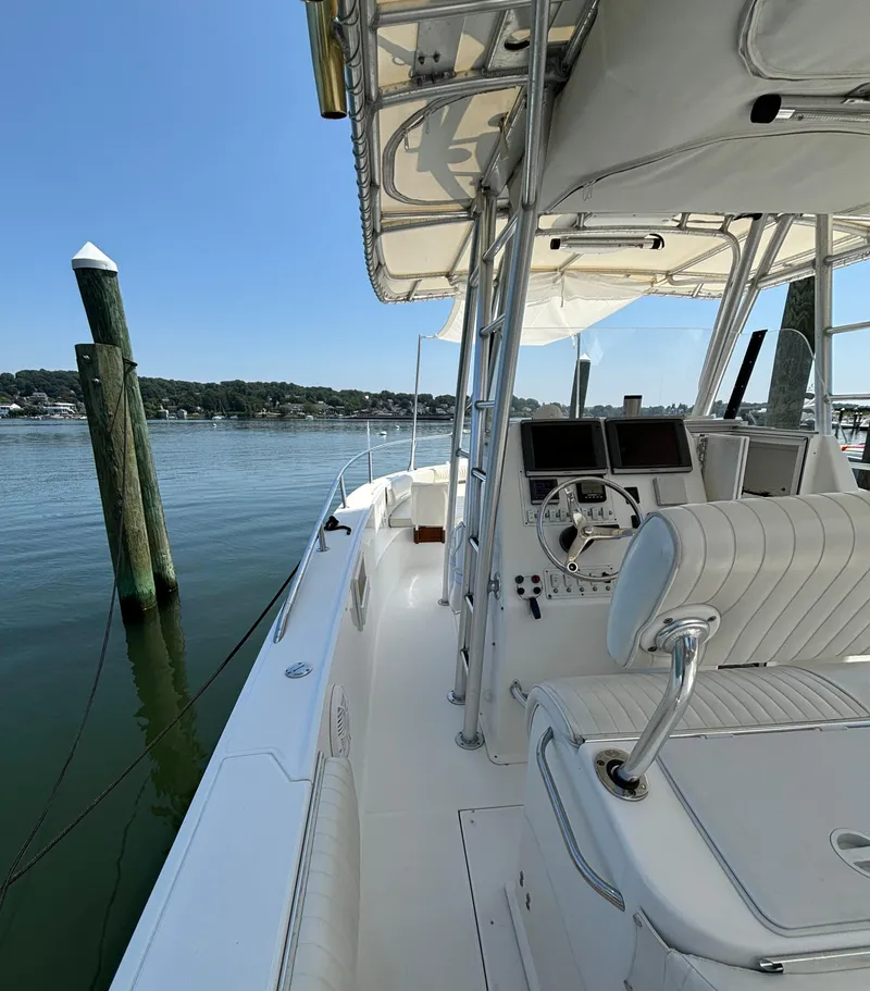 Slide: The Image of 2005 Stamas 310 Tarpon boat interior with helm, docked by calm waters. - 10