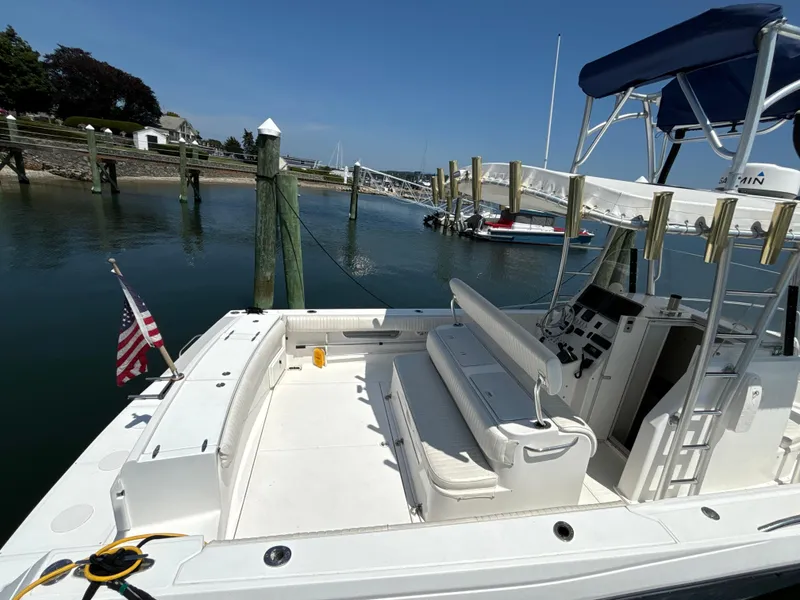 Slide: The Image of 2005 Stamas 310 Tarpon boat docked, featuring spacious deck and American flag. - 12
