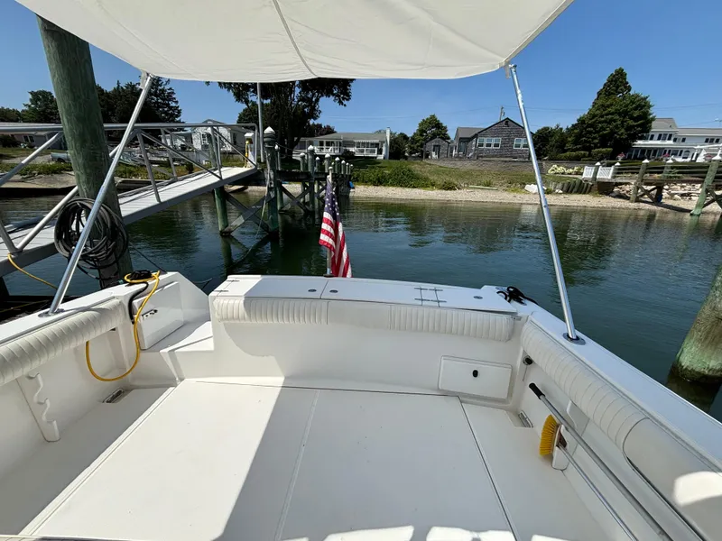 Slide: The Image of 2005 Stamas 310 Tarpon boat docked, featuring spacious deck and American flag. - 14