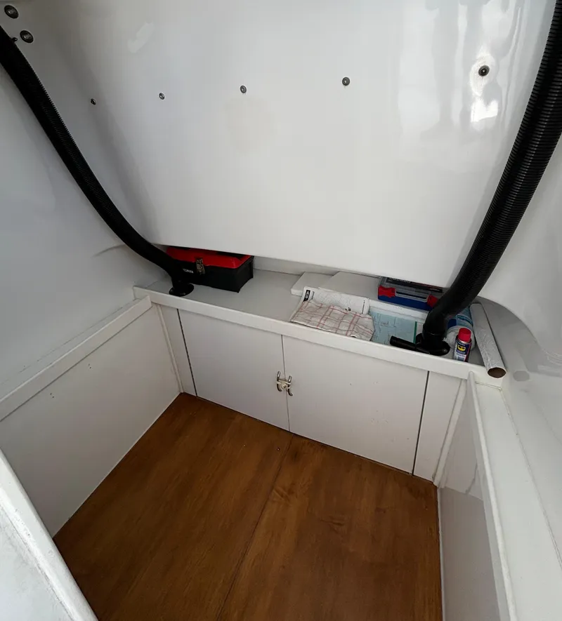 Slide: The Image of Interior storage area of a 2005 Stamas 310 Tarpon boat, featuring organized compartments. - 16