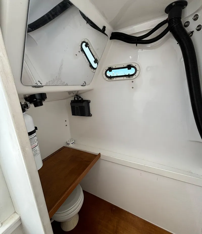 Slide: The Image of 2005 Stamas 310 Tarpon boat interior with mirror, portholes, and wooden shelf. - 17