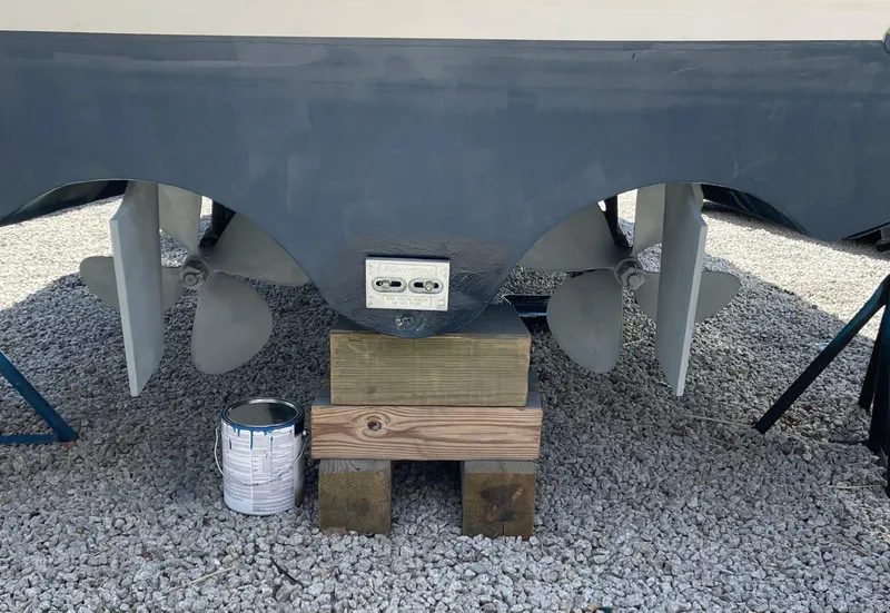 Slide: The Image of 2005 Stamas 310 Tarpon boat propellers on wooden blocks, gravel ground. - 19