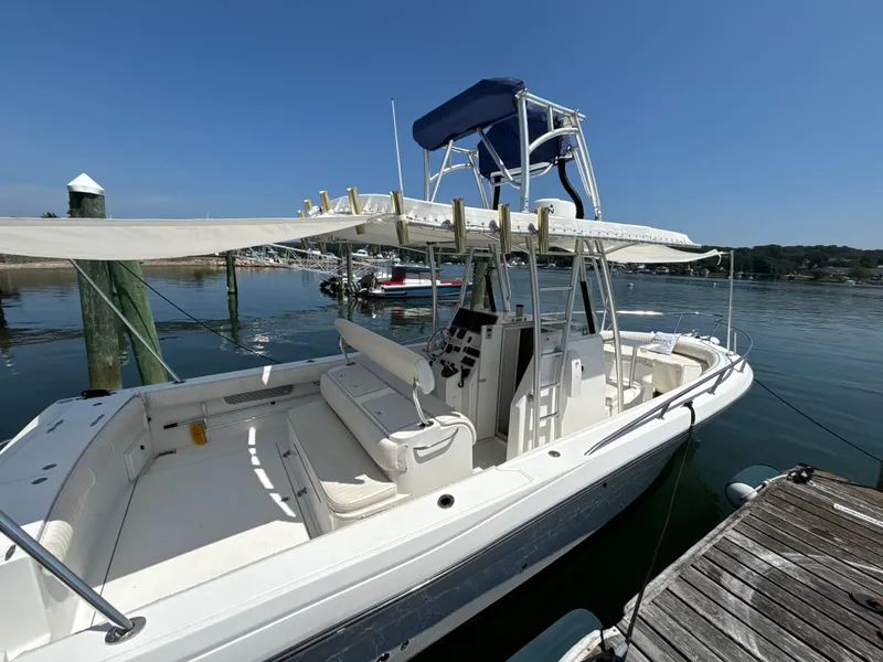 Slide: The Image of 2005 Stamas 310 Tarpon boat docked, featuring a spacious deck and canopy. - 2