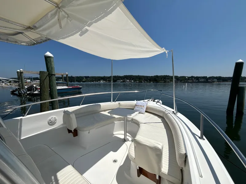 Slide: The Image of 2005 Stamas 310 Tarpon boat with canopy, docked by calm waters under clear blue sky. - 5