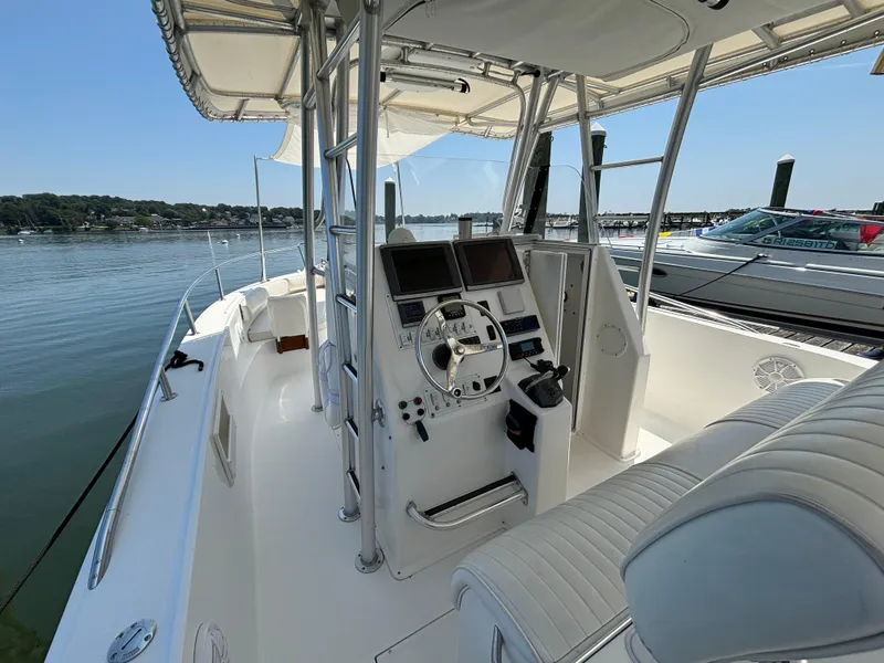 Slide: The Image of 2005 Stamas 310 Tarpon boat interior with helm and seating, docked by calm waters. - 7