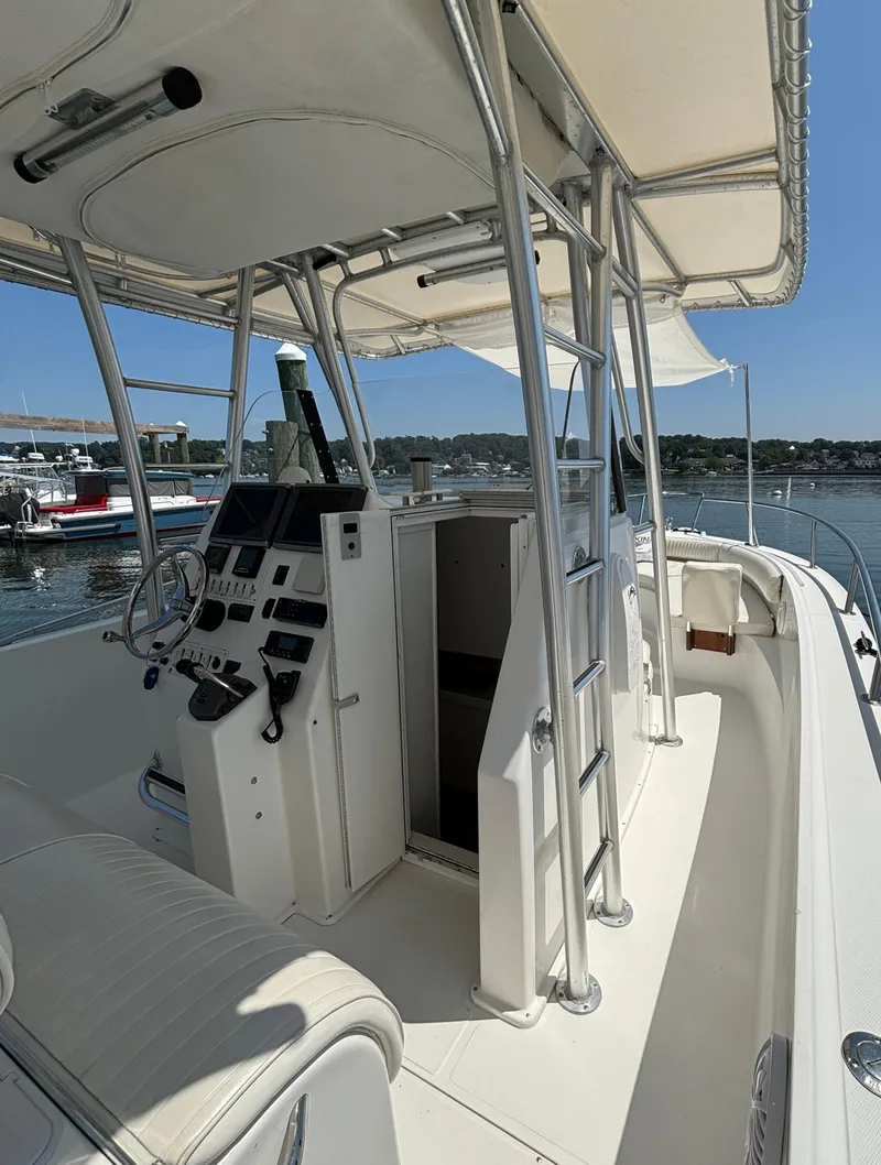 Slide: The Image of 2005 Stamas 310 Tarpon boat interior with helm, controls, and seating, docked at marina. - 9