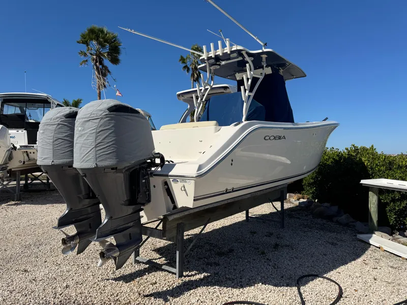Slide: The Image of 2013 Cobia 296 Center Console boat with dual outboard motors on display. - 0
