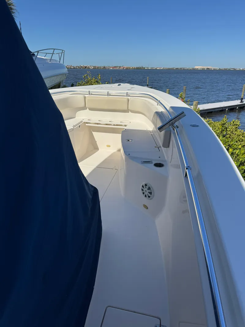Slide: The Image of 2013 Cobia 296 Center Console boat docked by a scenic waterfront. - 17
