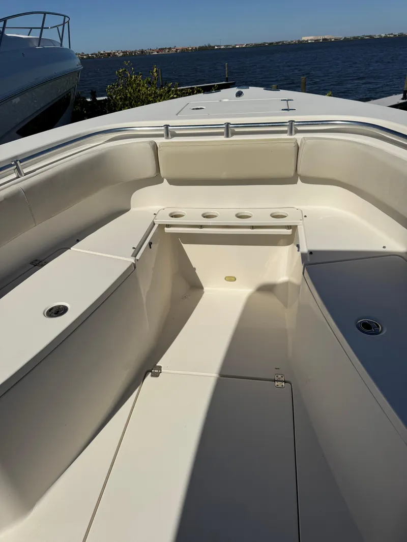 Slide: The Image of 2013 Cobia 296 Center Console boat interior, featuring spacious seating and cup holders. - 18