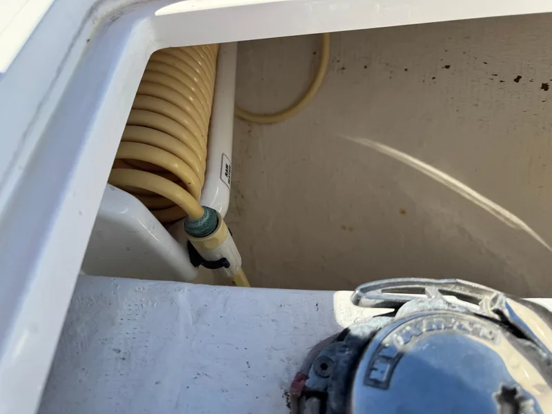 Slide: The Image of Close-up of 2013 Cobia 296 Center Console boat's coiled hose and fitting. - 19