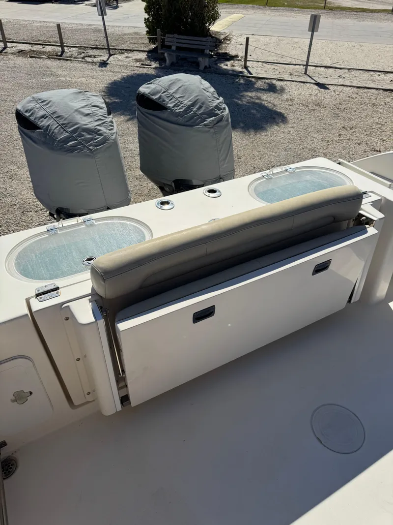 Slide: The Image of 2013 Cobia 296 Center Console boat with covered engines and seating area. - 2