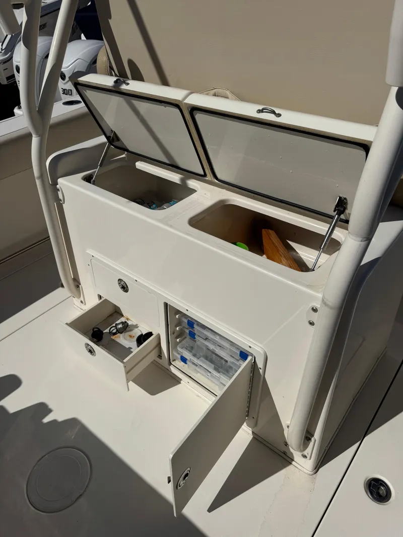 Slide: The Image of 2013 Cobia 296 Center Console boat storage compartments with open lids and drawers. - 5