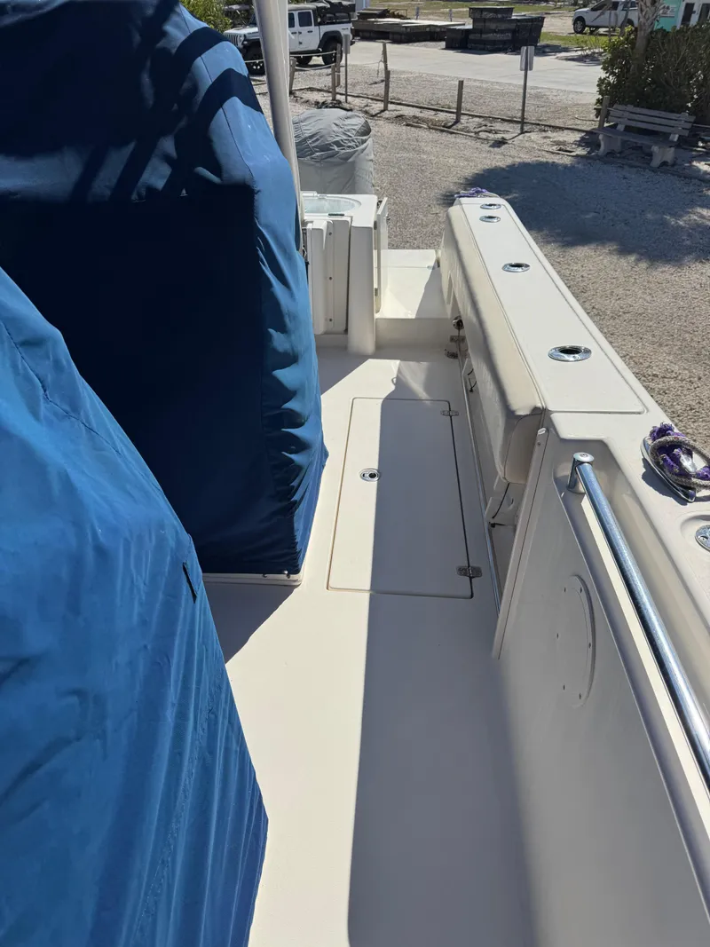 Slide: The Image of 2013 Cobia 296 Center Console boat deck with blue cover, docked outdoors. - 7