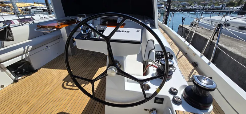 Slide: The Image of 2021 Beneteau Oceanis Yacht 54 cockpit with steering wheel and navigation controls. - 11