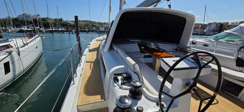 Slide: The Image of 2021 Beneteau Oceanis Yacht 54 docked, showcasing sleek deck and steering wheel. - 14