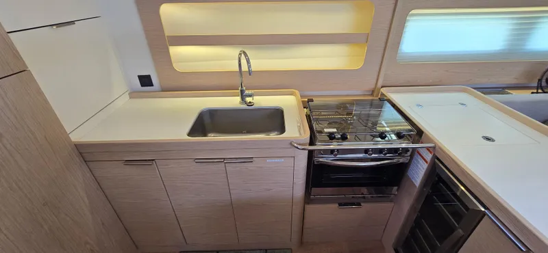 Slide: The Image of Modern kitchen in 2021 Beneteau Oceanis Yacht 54 with sink, stove, and wooden cabinetry. - 23