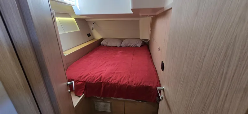 Slide: The Image of Cozy cabin interior of 2021 Beneteau Oceanis Yacht 54 with red bedding. - 25