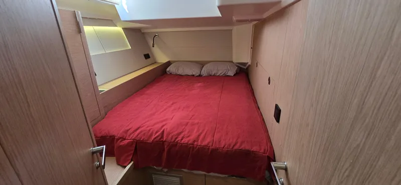 Slide: The Image of Cozy cabin interior of 2021 Beneteau Oceanis Yacht 54 with red bedding. - 26