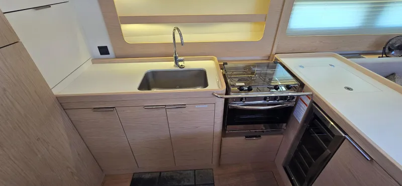 Slide: The Image of Modern kitchen in 2021 Beneteau Oceanis Yacht 54 with sink, stove, and wooden cabinetry. - 31