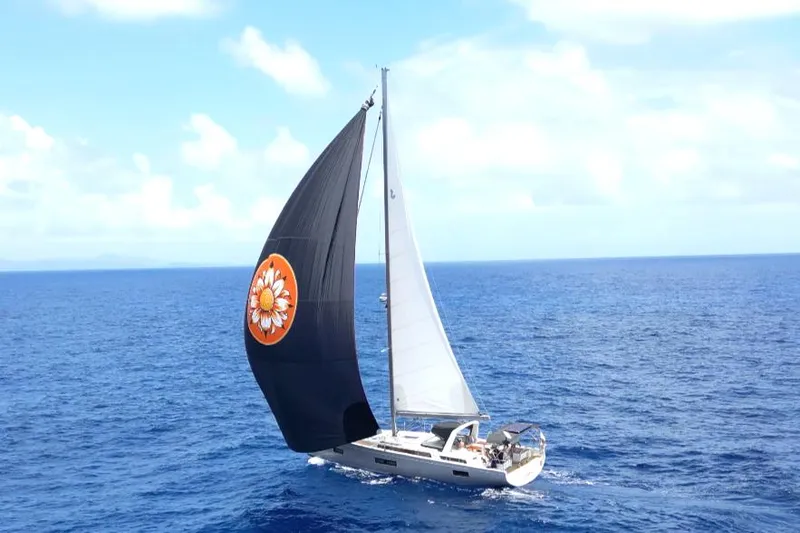 Slide: The Image of 2021 Beneteau Oceanis Yacht 54 sailing on open sea with distinctive black sail. - 4