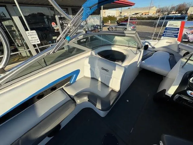 Slide: The Image of 2004 MasterCraft X-30 boat interior with white and blue seating, docked outdoors. - 14