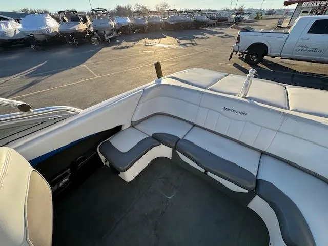 Slide: The Image of 2004 MasterCraft X-30 boat interior with white and gray seating in a sunny marina. - 15