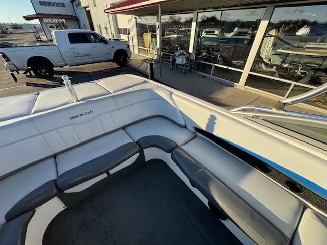 Slide: The Image of 2004 MasterCraft X-30 boat interior with gray seating, parked near a service center. - 16
