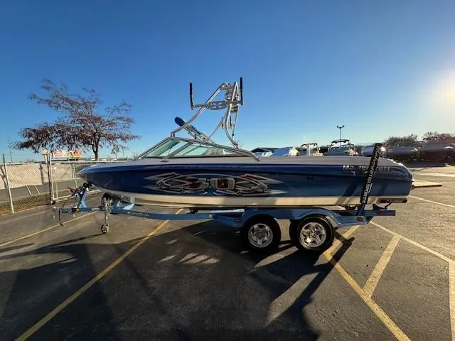 Slide: The Image of 2004 MasterCraft X-30 boat on trailer in parking lot, sunny day. - 6
