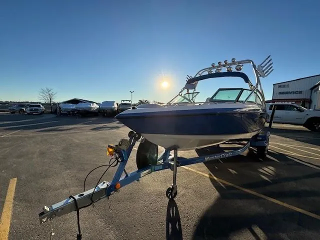 Slide: The Image of 2004 MasterCraft X-30 boat on trailer in parking lot, sunny day. - 7