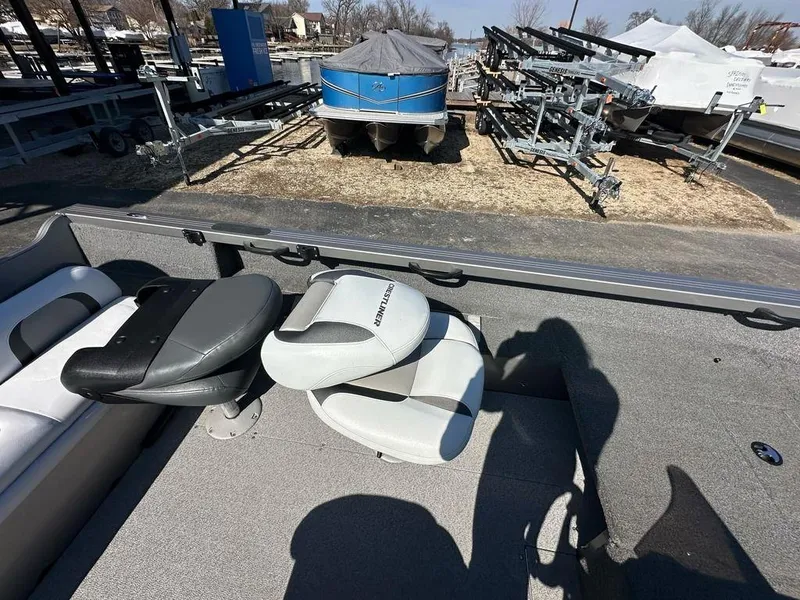 Slide: The Image of 2013 Crestliner Fish Hawk 1750 boat interior with seats, parked near trailers. - 11